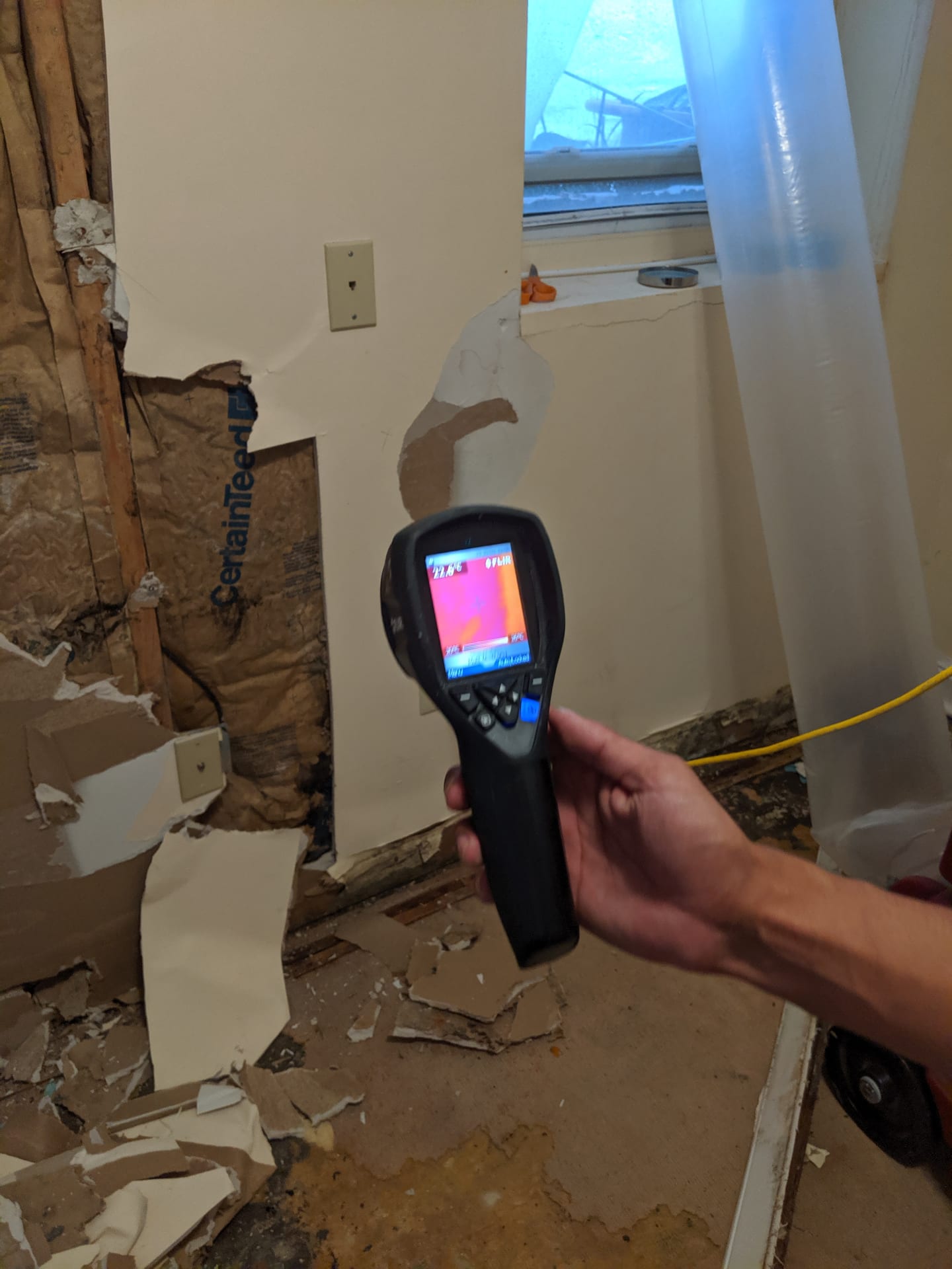 FLIR thermal imaging camera detecting hidden moisture behind wall